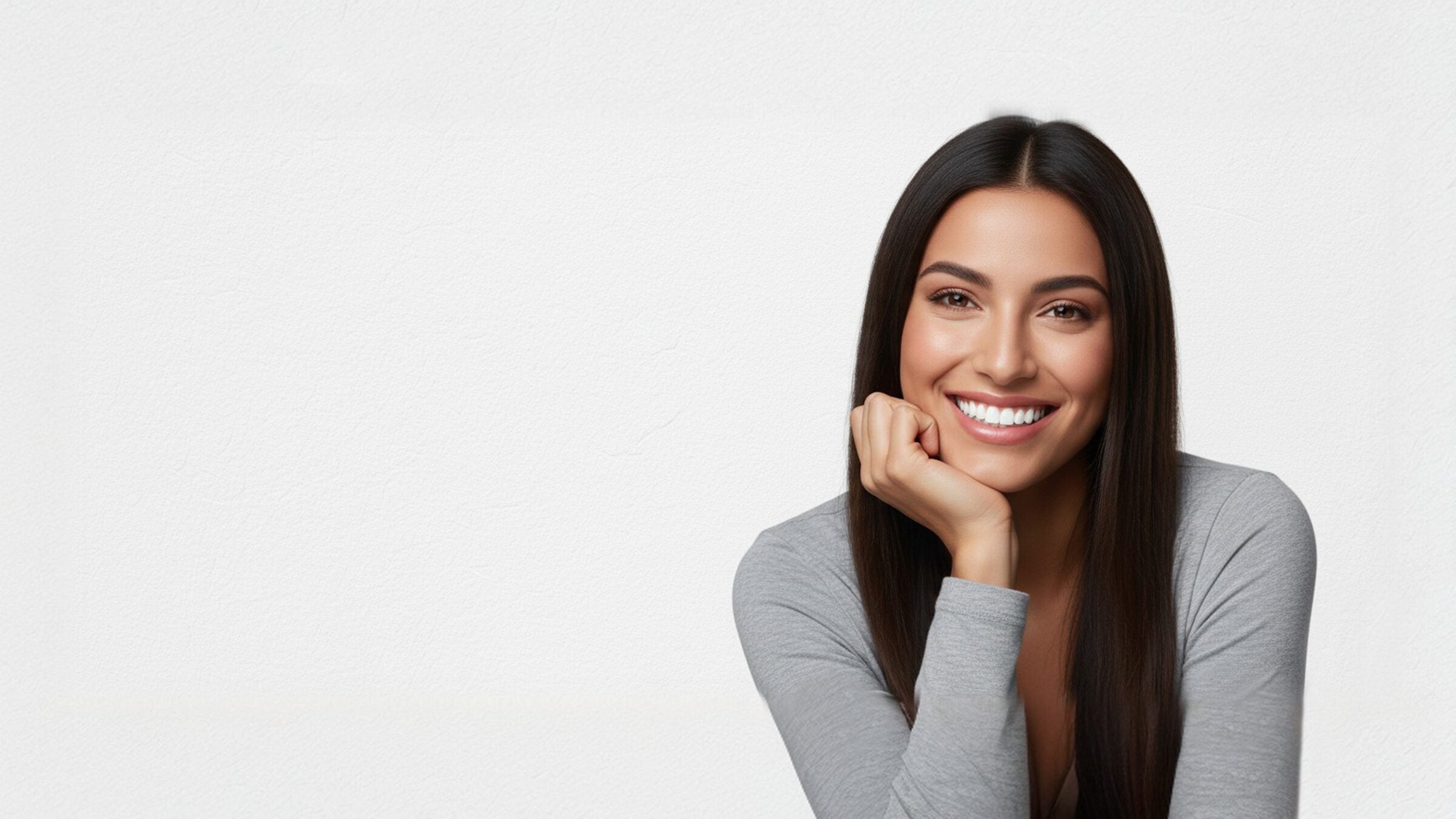 A woman smiling with her chin resting on her hand