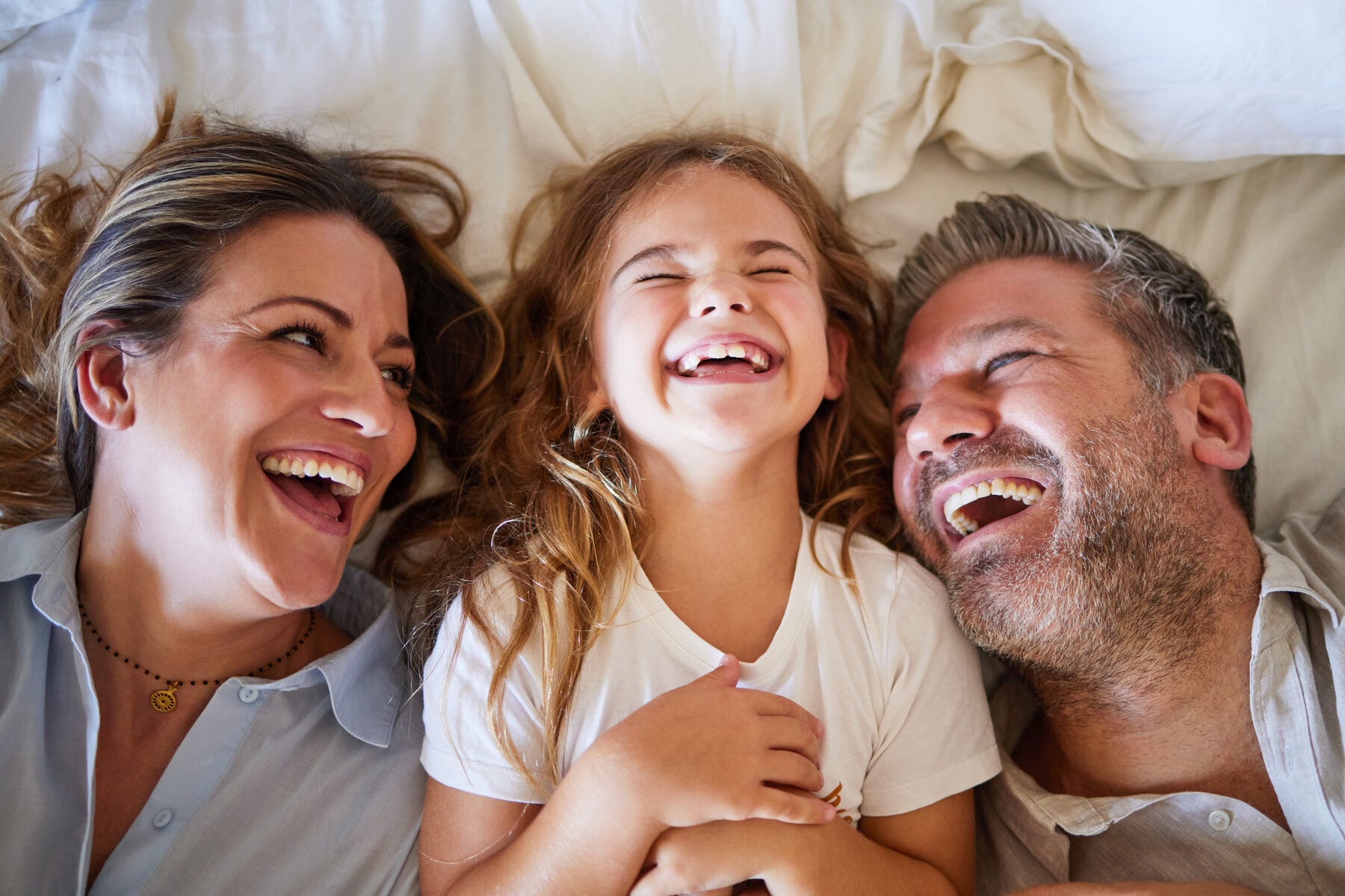 A mother, father and daughter laughing together