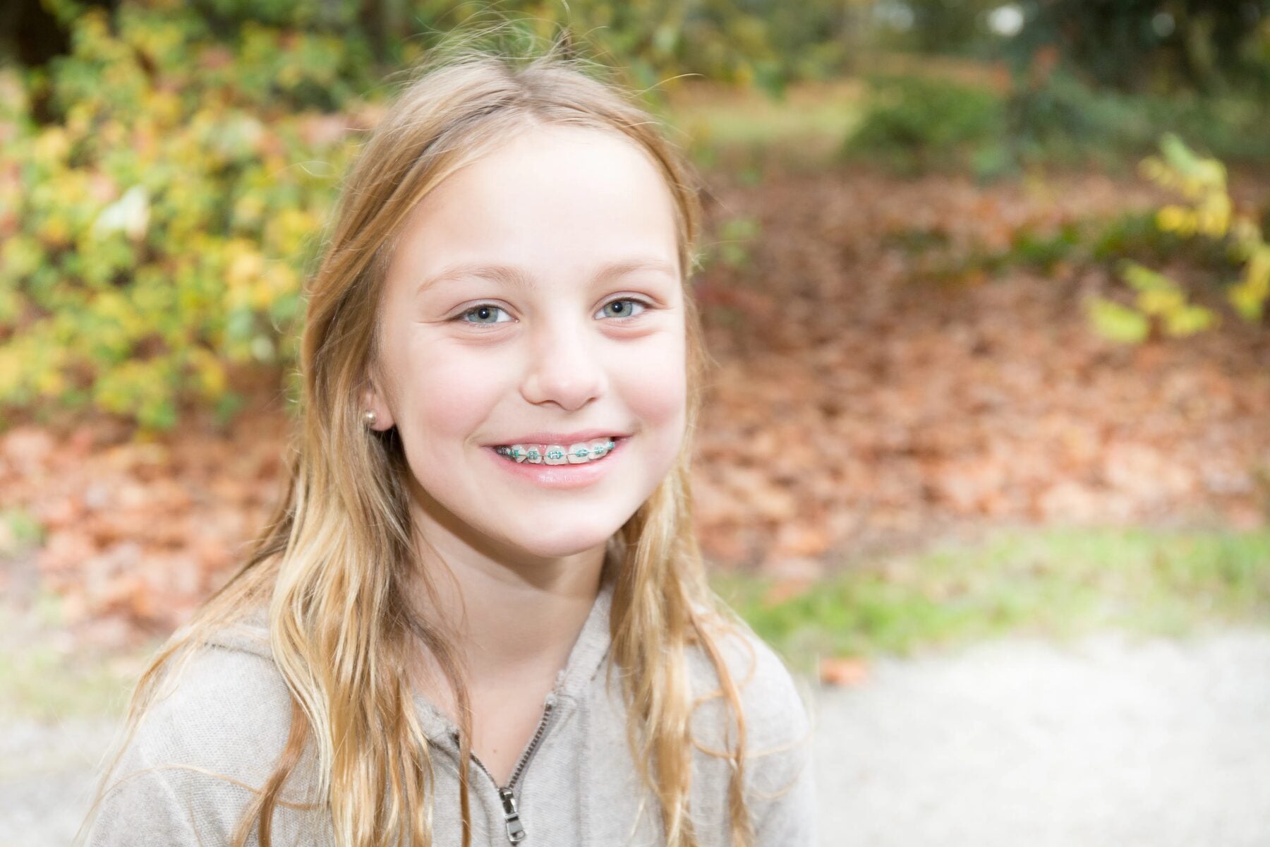 A girl with braces smiling outdoors